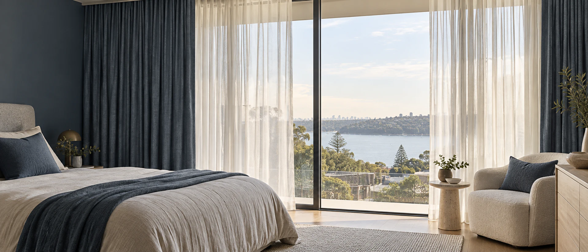 Layered sheer and deep blue curtains in a refined contemporary bedroom